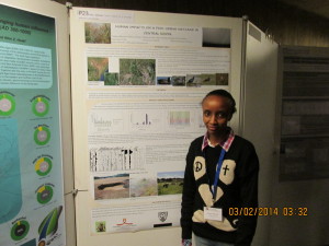 Esther next to her poster on Human imapcts on a peri-urban wetland in Central Kenya.